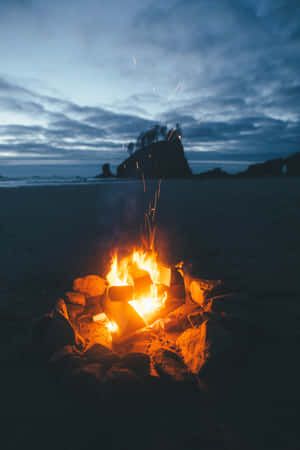 Warm Beach Campfire Under The Starry Night Sky Wallpaper