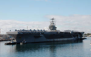 Warship Escorted By Small Boats Wallpaper