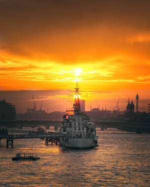 Warship Under An Orange Sunset Wallpaper