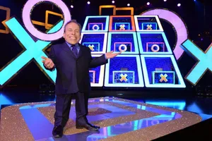 Warwick Davis Striking A Smiling Pose During An Event Wallpaper