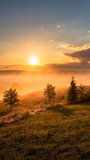 Watching The Sun Rise Over A Misty Mountain Wallpaper