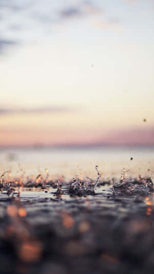 Water Splashes On The Beach At Sunset Wallpaper