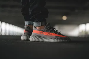 Wearing A Yeezy Boost 350in Orange Wallpaper