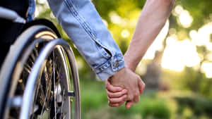 Wheelchair User Holding Hands Outdoors Wallpaper