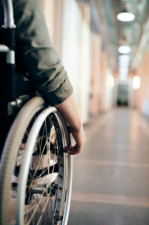 Wheelchair_ User_ In_ Hallway Wallpaper