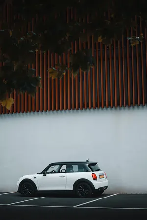 White Mini Cooper Parked Beside Modern Wall Wallpaper