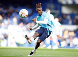 Wilfried Zaha Kicking Football On Field Wallpaper