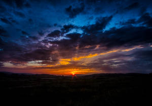 Witness The Beauty Of Dark Mountains In This Beautiful Orange Sunrise! Wallpaper