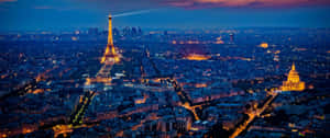 Witness The Beauty Of The Paris Skyline At Night Wallpaper