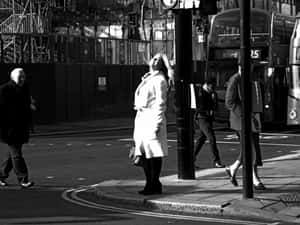 Woman Amid Random People Crossing A City Street Wallpaper