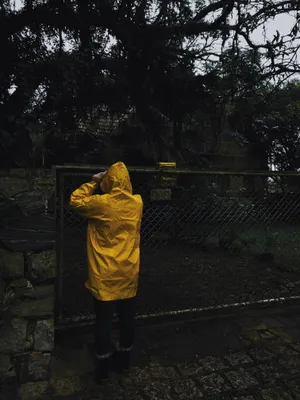 Woman Enjoying Rain In Vibrant Yellow Raincoat Wallpaper