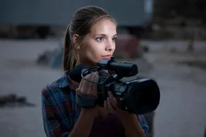 Woman Holding Camera Outdoors Wallpaper