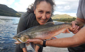 Woman Holding Large Arctic Char Wallpaper