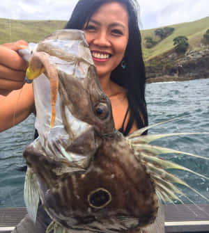 Woman Holding Large Doryfish Catch.jpg Wallpaper