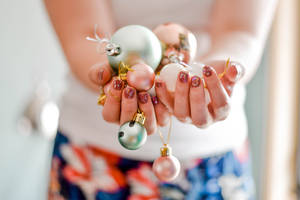 Woman Holding Pretty Christmas Balls Wallpaper