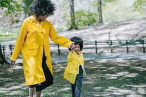 Woman In A Yellow Raincoat Enjoying The Rain Wallpaper