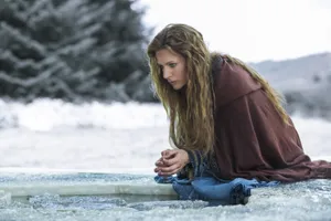 Woman Kneelingby Ice Holein Winter Wallpaper