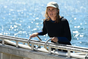 Woman Leaningon Railingby Sea Wallpaper