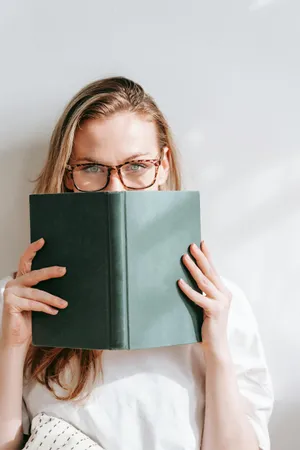 Woman Peeking Over Book Wallpaper