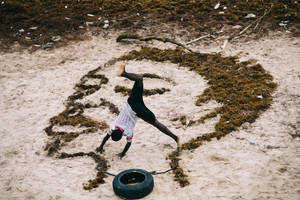 Woman Tumbling On Artwork In Sierra Leone Wallpaper