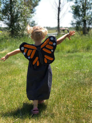 Woman Wearing A Unique Butterfly Wing Dress Wallpaper