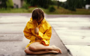 Woman Wearing Vibrant Yellow Raincoat On A Rainy Day Wallpaper