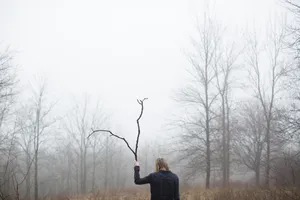 Woman With Branch In Foggy Forest Wallpaper
