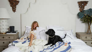 Womanand Dog Relaxingin Bedroom Wallpaper