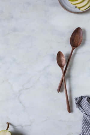 Wooden Spoonsand Sliced Pearon Marble Background Wallpaper
