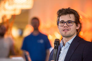 World Chess Champion Magnus Carlsen Speaking At An Event Wallpaper