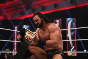 Wwe Superstar Drew Mcintyre Triumphantly Holding The Raw Championship Belt. Wallpaper