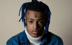 Xxxtentacion Sits Atop His Laptop, Surrounded By Books And Art Supplies Wallpaper