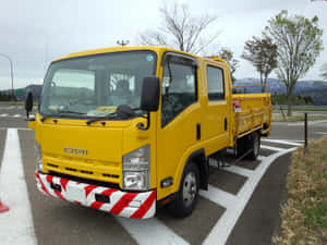 Yellow Isuzu Elf Truck Parked Wallpaper