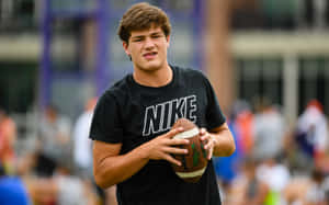 Young Athlete Holding Football Wallpaper