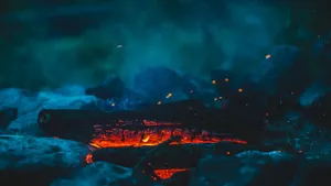 Young Couple Hiking Under A Vibrant Red Sunset Wallpaper