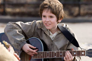 Young Freddie Highmore Playing Guitar Wallpaper