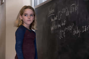 Young Girl Standing Before Blackboard Wallpaper