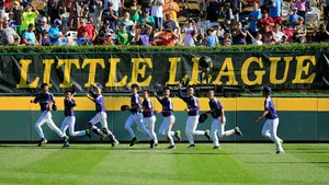 Young Little League Baseball Players Competing On The Field Wallpaper