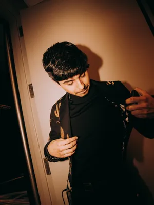 Young Man Adjusting Jacket Wallpaper