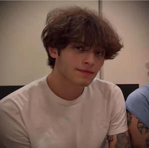 Young Manwith Curly Hairand White Shirt Wallpaper