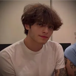 Young Manwith Curly Hairand White Shirt Wallpaper