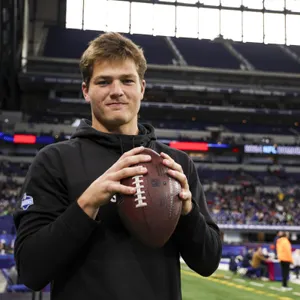 Young Quarterback Holding Football Stadium Wallpaper