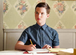 Young Sheldon Studyingat Desk Wallpaper