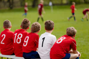 Youth Soccer Team Bench Watching Game Wallpaper