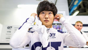 Yuki Tsunoda Putting Ear Buds Wallpaper