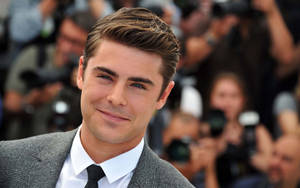 Zac Efron Grinning Cheekily In A Close-up Wallpaper