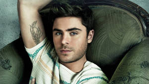 Zac Efron Living His Best Life In A Cozy Green Couch. Wallpaper